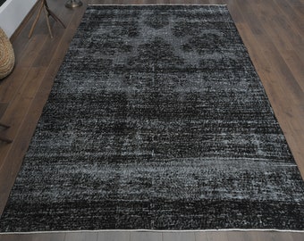 May include: A black and white distressed area rug with a subtle pattern. The rug has a faded, vintage look and is made of a soft, durable material.