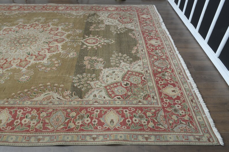 May include: A vintage rug with a floral pattern in shades of red, green, and beige. The rug has a fringed edge and a central medallion design.