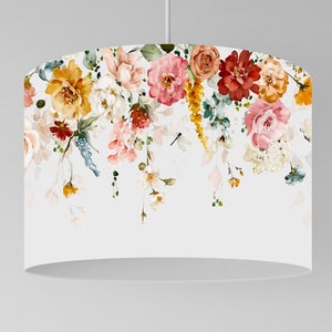 May include: White lampshade with a watercolour floral design. The design features flowers in yellow, pink, red, and peach, with green leaves and stems. The flowers are arranged in a cascading pattern, creating a decorative effect.