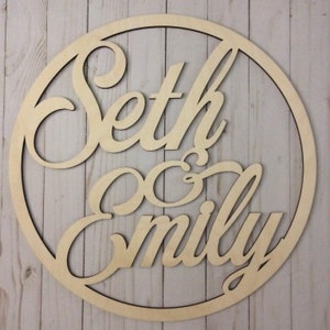 May include: A wooden circle with the names Seth & Emily cut out in a cursive font.