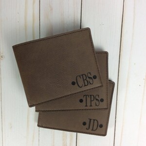 May include: Three brown leather wallets with personalized initials. The initials are "CBS", "TPS", and "JD".