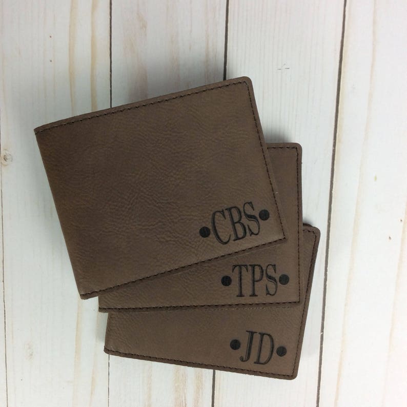 May include: Three brown leather wallets with personalized initials. The initials are "CBS", "TPS", and "JD".