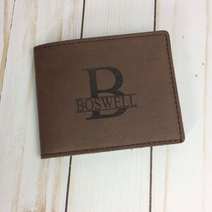 May include: Brown leather wallet with a personalized monogram. The monogram features the letter "B" with the name "BOSWELL" underneath.