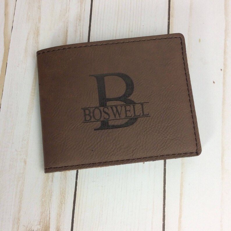 May include: Brown leather wallet with a personalized monogram. The monogram features the letter "B" with the name "BOSWELL" underneath.