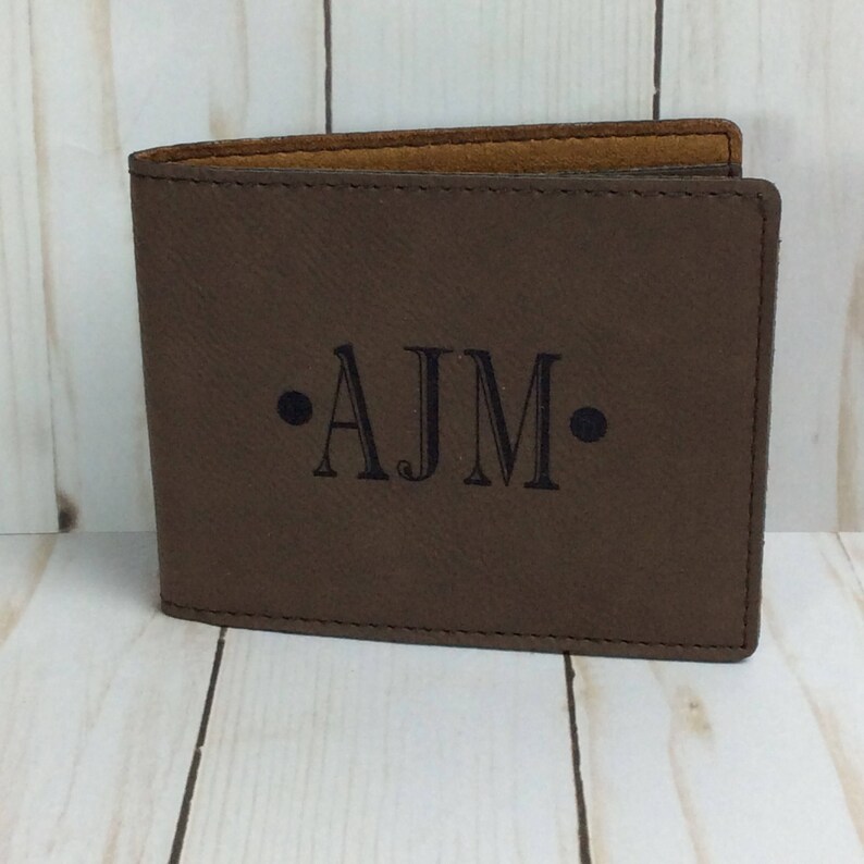 May include: A brown leather wallet with the initials "AJM" embossed in black.