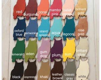 May include: A collection of 18 wooden owl shapes painted in various colors, including red, coral, burgundy, pink, blue, aqua, green, yellow, brown, black, white, and silver. The owls are arranged in three rows of six owls each.