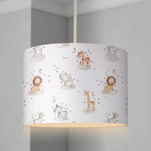 May include: White lampshade featuring a light brown, cream, and blue animal print. The animals include a lion, giraffe, rhino, elephant, zebra, and tiger. The print also includes stars and crescent moons.
