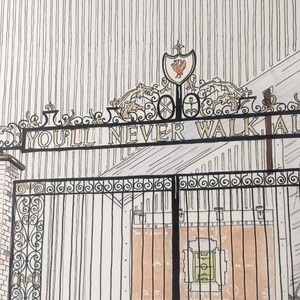 May include: A black metal gate with intricate scrollwork and the words "You'll Never Walk Alone" inscribed on it. The gate is closed and behind it is a brick building with a red and green soccer field.