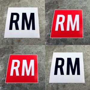 May include: Four square signs with the letters "RM" in black and white on a white background and red and white on a red background.