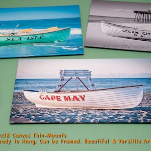 May include: Three canvas prints featuring coastal scenes. One shows a teal boat with "SEA ISLE" on it. Another is a black and white image of a boat with "OCEAN CITY N.J." The third depicts a boat with "CAPE MAY".