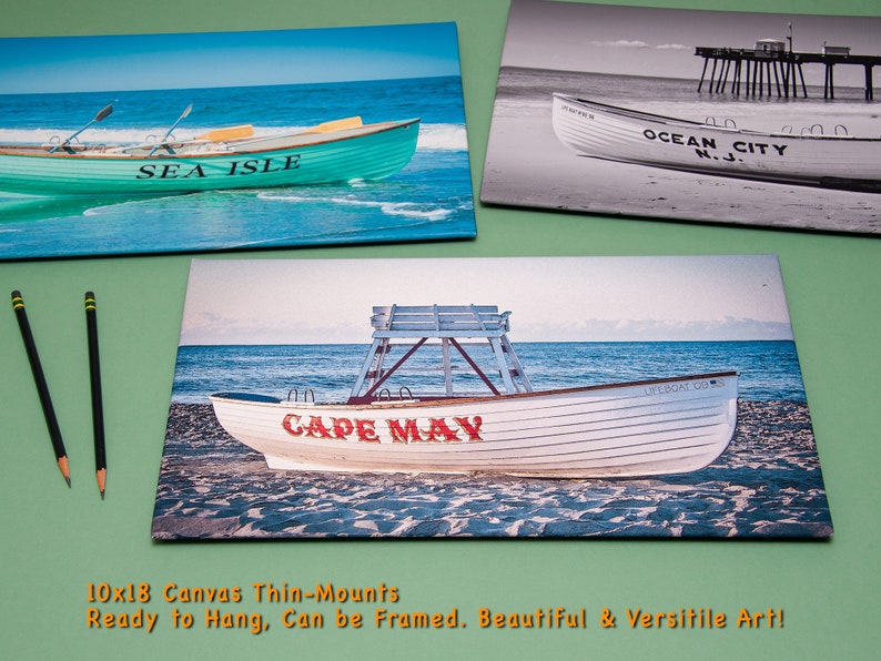 May include: Three canvas prints featuring coastal scenes. One shows a teal boat with "SEA ISLE" on it. Another is a black and white image of a boat with "OCEAN CITY N.J." The third depicts a boat with "CAPE MAY".