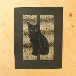 Op de afbeelding: Zwarte kattenkunstprint op een zwarte achtergrond met gouden tekst. De kat zit rechtop met gloeiende gele ogen. De achtergrond heeft een vintage-stijl schrift.