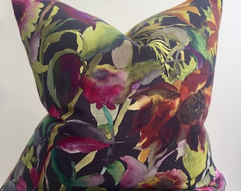 May include: A black pillow with a watercolor floral print featuring pink, red, yellow, and green flowers on a dark background.