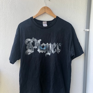 Könnte beinhalten: Schwarzes T-Shirt mit einem weißen Aufdruck des Wortes "Player" in einer stilisierten Schrift.