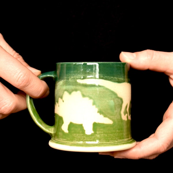 Dinosaurier Kindertasse aus Keramik, handgedreht auf der Töpferscheibe, aus weißem Ton, grün glasiert, weiße Dinos, Kinder, Tee, Kakao