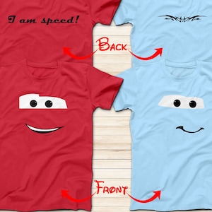 May include: Two t-shirts, one red and one light blue, with a cartoon face of Lightning McQueen from the Cars movie. The red shirt has the text "I am speed!" on the back.