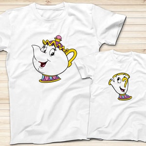 May include: Two white t-shirts with a cartoon image of Mrs. Potts and Chip from Beauty and the Beast. The larger shirt features Mrs. Potts with a pink, yellow, and purple design. The smaller shirt features Chip with a yellow, pink, and purple design.
