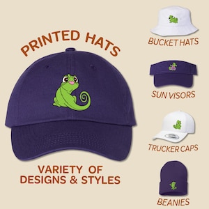 May include: A variety of printed hats featuring a green chameleon design. The hats include a purple baseball cap, a white bucket hat, a purple sun visor, a white trucker cap, and a purple beanie.