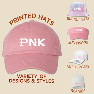 May include: A variety of hats with the word "PNK" printed on them. The hats include a pink baseball cap, a pink bucket hat, a pink sun visor, a white trucker cap, and a white beanie.