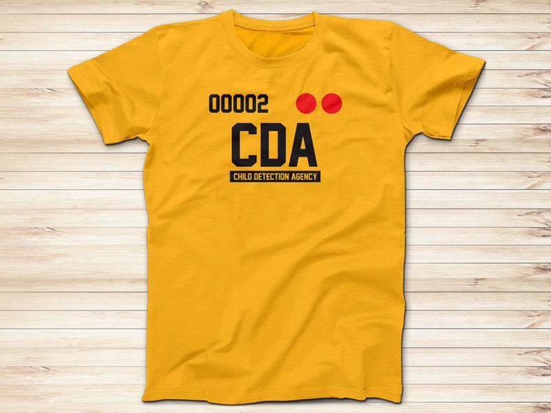 May include: A yellow t-shirt with black text that reads "00002 CDA CHILD DETECTION AGENCY" and two red dots.