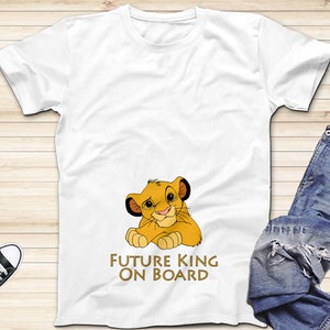 May include: White t-shirt with a cartoon image of Simba from The Lion King. The shirt has the text "Future King On Board" printed on it.