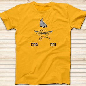 May include: Yellow t-shirt with a cartoon face wearing glasses and the text "CDA 001".