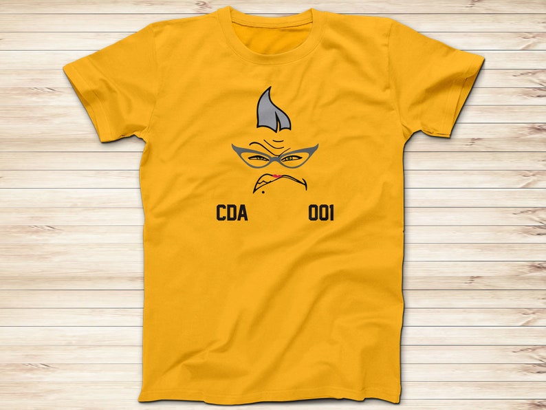 May include: Yellow t-shirt with a cartoon face wearing glasses and the text "CDA 001".