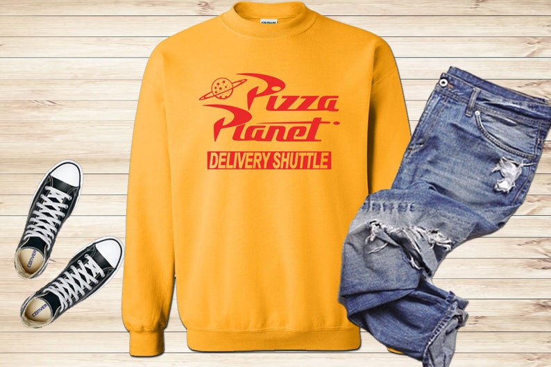 May include: Yellow sweatshirt with a red "Pizza Planet" logo and the words "Delivery Shuttle" printed on the front.