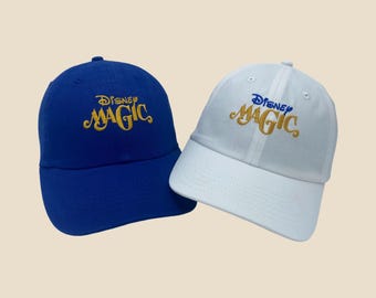 May include: Two baseball caps, one blue and one white, with the text "Disney Magic" embroidered in gold and blue.