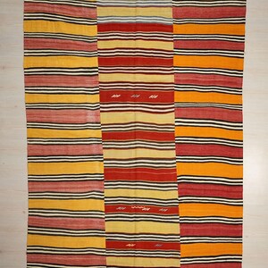 a vibrant, colorful textile with a repeating pattern of horizontal stripes in various colors, including red, yellow, and orange.