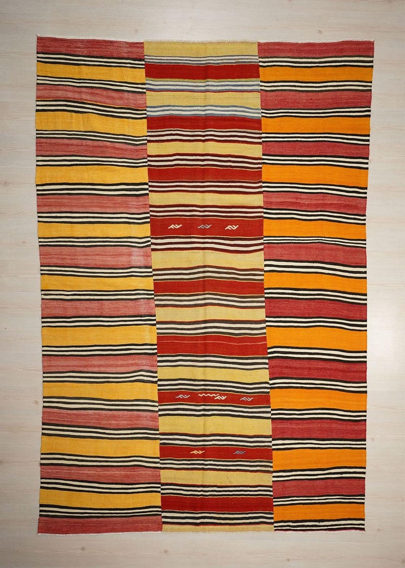 a vibrant, colorful textile with a repeating pattern of horizontal stripes in various colors, including red, yellow, and orange.