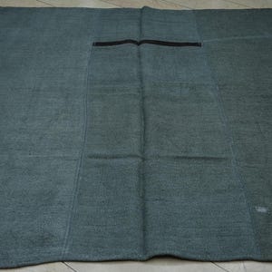 a large, square-shaped rug with a dark green color and a black stripe running through the center.