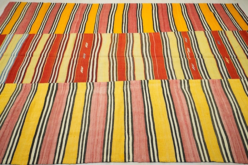 a vibrant, multi-colored rug with a repeating pattern of stripes in various colors, including red, yellow, and black.