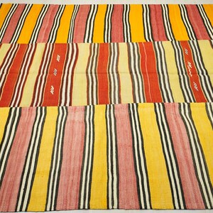 a vibrant, multi-colored rug with a repeating pattern of stripes in various colors, including red, yellow, and black.