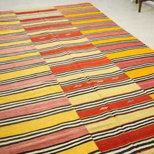 a large, colorful rug with a striped pattern in shades of red, yellow, and black.