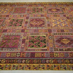 a large, colorful, and intricately patterned rug or carpet with a variety of geometric shapes and designs.