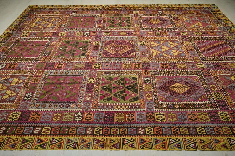a large, colorful, and intricately patterned rug or carpet with a variety of geometric shapes and designs.