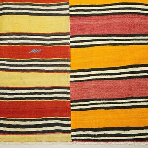 a colorful rug with a striped pattern in red, yellow, and black.