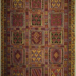 The image is a vibrant and intricate textile with a geometric pattern, featuring a variety of shapes and colors.