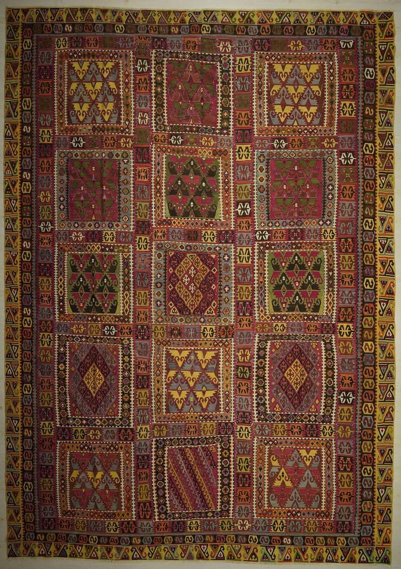 The image is a vibrant and intricate textile with a geometric pattern, featuring a variety of shapes and colors.