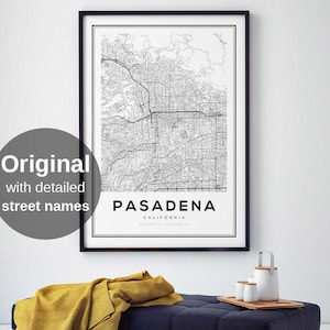 May include: A framed black and white map print of Pasadena, California, with detailed street names. The print hangs above a navy blue tufted bench with a mustard yellow blanket. A wooden tray holds white ceramic cups and a teapot.