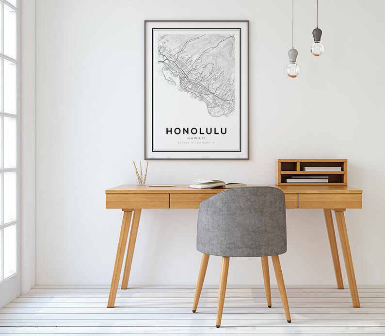 K&ouml;nnte beinhalten: Ein heller Holzschreibtisch mit zwei Schubladen und einem grauen Stoffstuhl. An der Wand &uuml;ber dem Schreibtisch h&auml;ngt eine gerahmte Karte von Honolulu, Hawaii. Von der Decke h&auml;ngen drei Gl&uuml;hbirnen.