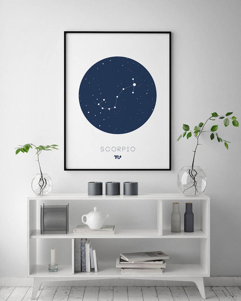 Puede incluir: Una impresi&oacute;n enmarcada en negro con un c&iacute;rculo azul que representa la constelaci&oacute;n de Escorpio con estrellas blancas. El texto "SCORPIO" y el s&iacute;mbolo astrol&oacute;gico de Escorpio est&aacute;n impresos debajo del c&iacute;rculo.