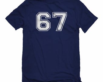 May include: Navy blue t-shirt with the number "67" in white, outlined in navy blue. The number is in a collegiate font. The shirt has short sleeves and a crew neck.
