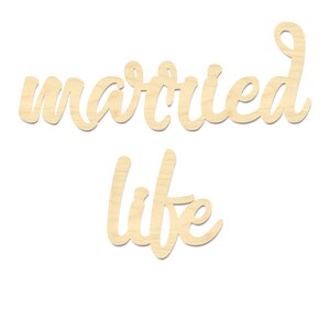 K&ouml;nnte beinhalten: Holzausschnitt des Satzes "married life" in einer kursivschriftlichen Schriftart. Der Ausschnitt ist hellbraun und perfekt f&uuml;r eine Hochzeits- oder Jubil&auml;umsdekoration.