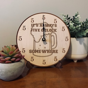 May include: A wooden clock with a beer mug design. The clock face reads "It's Always Five O'Clock Somewhere".