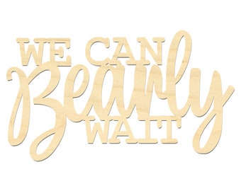 May include: A light-colored wooden cutout sign featuring the text WE CAN BEARLY WAIT. The words WE CAN and WAIT are in a bold, block-style font, while the word BEARLY is written in a large, flowing, cursive script that connects the letters.