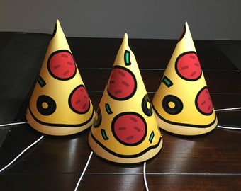 May include: Three yellow and red pizza party hats with white strings.