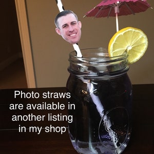 Puede incluir: Un tarro de cristal lleno de un l&iacute;quido morado, una rodaja de lim&oacute;n y una pajita con una foto de la cara de un hombre en ella. Tambi&eacute;n hay un paraguas de papel rosa en el tarro. El texto "Photo straws are available in another listing in my shop" est&aacute; escrito debajo del tarro.
