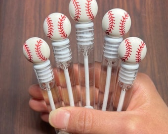 May include: Five clear plastic bubble wands with white tops and red and white baseball-themed toppers.